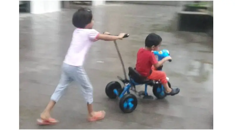 kids playing on pedal and push ride on toy